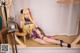 A woman in a purple and gold outfit sitting on a window sill.