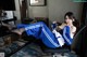 A woman in a blue and white outfit sitting on a chair.