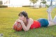 A woman laying on the grass with a basketball.