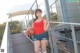 A woman in shorts and a red shirt holding a basketball.