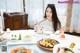 A woman sitting at a table with a plate of food.